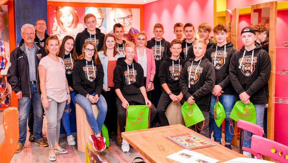 Grizzlys-Geschäftsführer Rainer Schumacher (ganz links im Bild) und die U17 der Young Grizzlys bei Optiker Ehme de Riese.